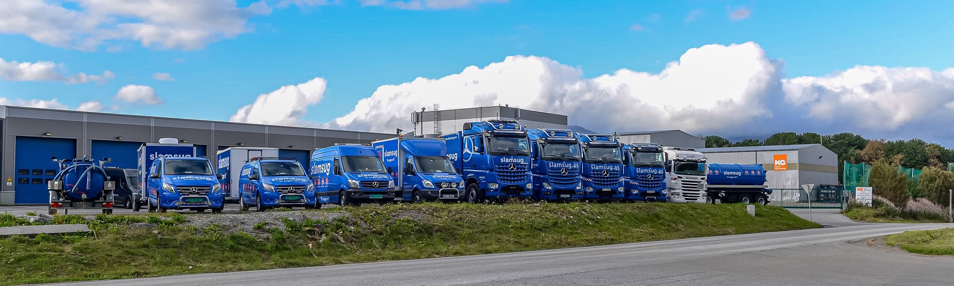 En rekke lastebiler og andre nyttekjøretøy som står parkert på rekke