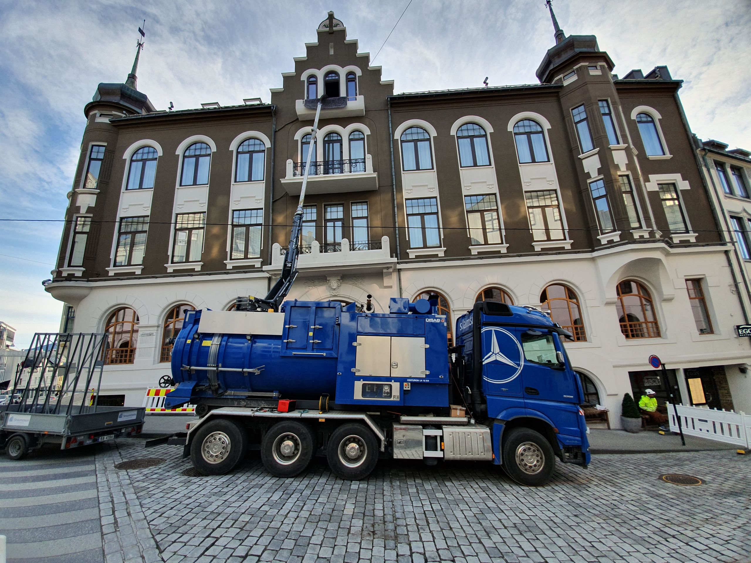 Slamsugebil står parkert foran et bygg